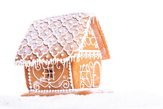 gingerbread house on a snow over white backgrond