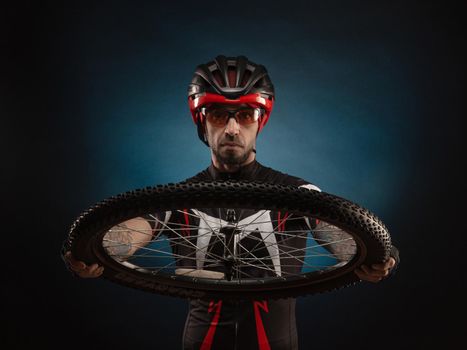 guy-cyclist in a Bicycle helmet with a Bicycle wheel