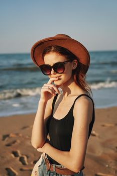 pretty woman in hat and sunglasses on the beach walk sun. High quality photo