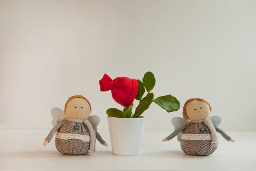 green cactus with red christmas hat or bonnet in white pot with christmas funny decorations. home plant. Funny decorated flower with Santa's hat waiting for new year party