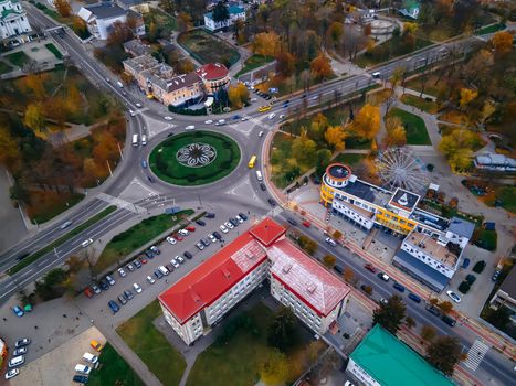 Aerial view of roundabout road with circular cars in small european city at autumn cloudy day, Kyiv region, Ukraine