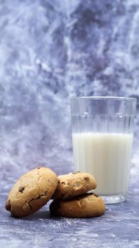 American gluten free chocolate chip cookies with glass glass of vegetable milk on gray background. Chocolate chip cookies. Sweet pastries, dessert. Culinary background. Vertical photography