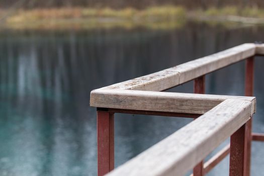 Curved pedestrian catwalk with typical wooden parapet of the lake