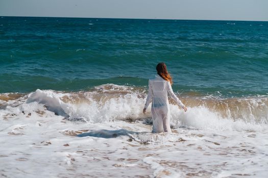 Woman in white dress freedom walk on ocean island. High quality photo