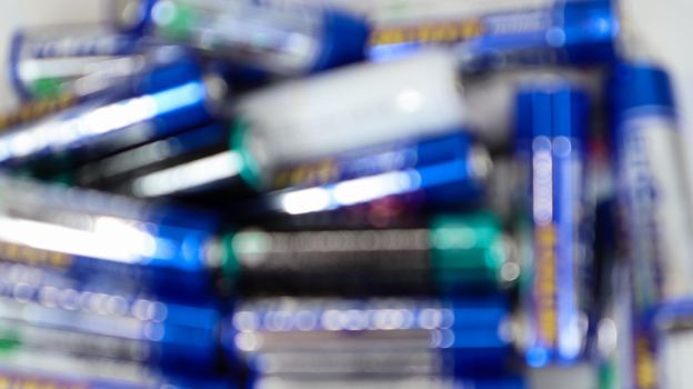 Defocused multicolored random batteries on a AA table, top view