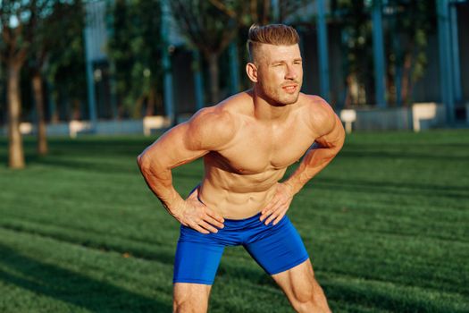 man with muscular body exercising in summer park. High quality photo