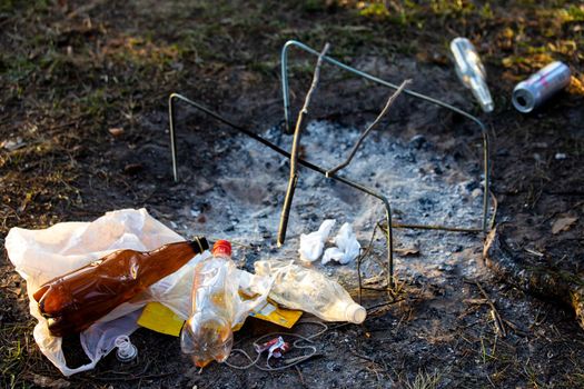 A pile of garbage in the forest park near the campfire site. environmental pollution.