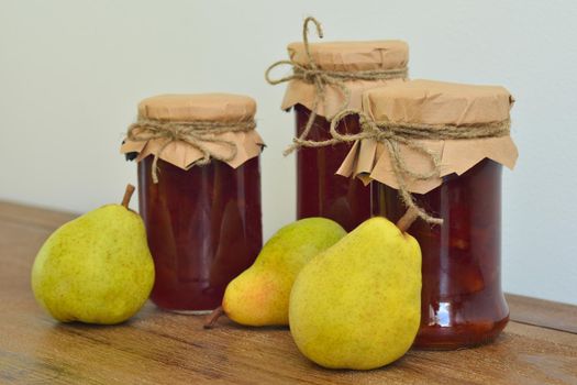 Pears and glass jars of jam on the table.