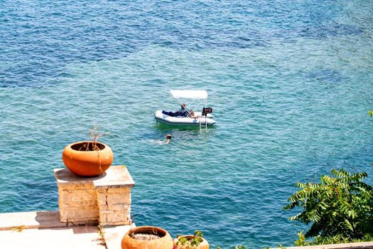 porto santo stefano,italy july 24 2021:small boats on the sea with bathers