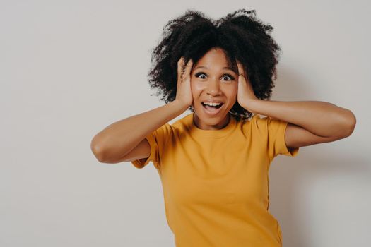 Woman plugging ears with arms does not want to listen hard rock or loud music. African American young female ignoring noise covering head with hands avoiding loud sounds or unwanted conversations