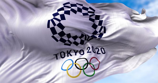 Tokyo, Japan, July 2021: Tokyo 2020 olympic flag waving in the wind. Tokyo 2020 olympics games were postponed to 2021 due to the covid-19 pandemic