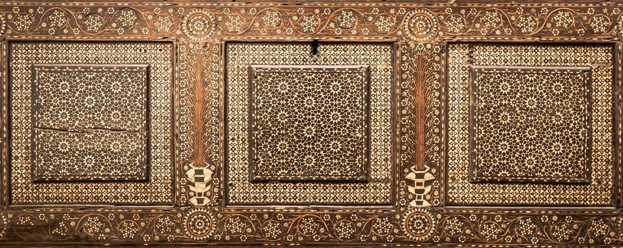 Antique art of wood decoration on a 15th century Italian furniture. Vintage and gothic background image.