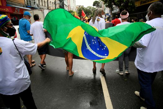 salvador, bahia, brazil - july 24, 2018: protester carries the Brazilian flag during protest against the government of President Jair Bolsonaro in the city of Salvador.