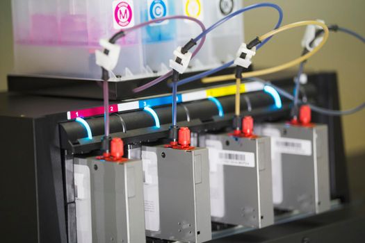 Color ink cartridges inside professional printing machine, close up
