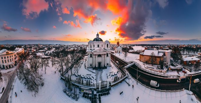 Panoramic aerial view of the cathedral and church in snow-covered small european city at bright winter sunset Gorgeous sunset and clouds.. Drone. Winter. Ukraine, 2021