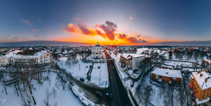 Panoramic aerial view of the cathedral and church in snow-covered small european city at bright winter sunset Gorgeous sunset and clouds.. Drone. Winter. Ukraine, 2021