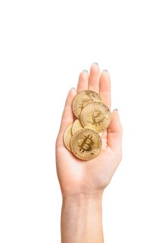 Many gold bitcoins coins on female palm hand isolated on a white background, top view. Cryptocurrency or virtual money.