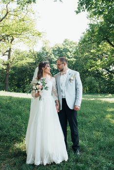 Wedding photo of the bride and groom in a gray-pink color on nature in the forest and rocks