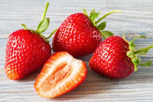 Fresh strawberry close up on the light wood background