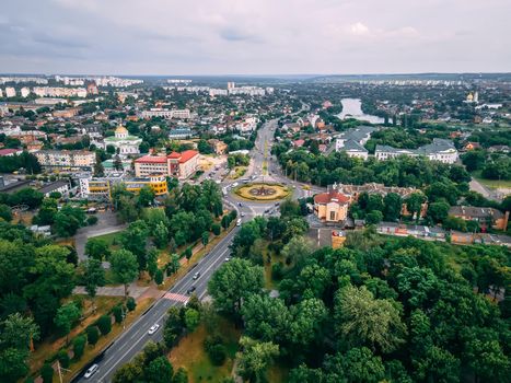 Aerial view of roundabout road with circular cars in small european city at summer afternoon, Kyiv region, Ukraine