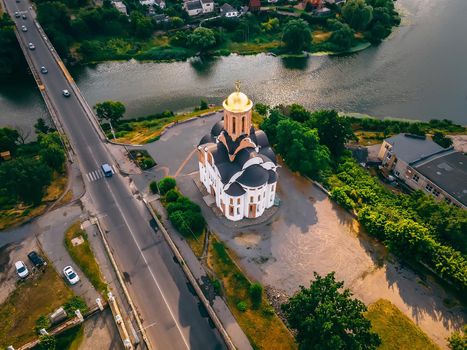 Aerial view of old church near river and bridge in small european city at summer day, Kyiv region, Ukraine