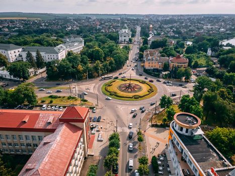 Aerial view of roundabout road with circular cars in small european city at summer afternoon, Kyiv region, Ukraine