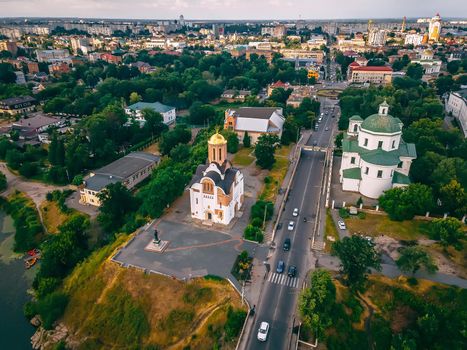 Aerial view of two old churches near river and bridge in small european city at summer day, Kyiv region, Ukraine