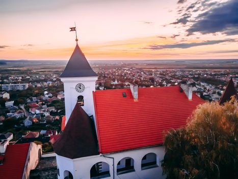 Aerial view of medieval castle on mountain in small european city in autumn season. Palanok castle, Mukachevo, Ukraine