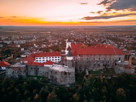 Aerial view of medieval castle on mountain in small european city in autumn season. Palanok castle, Mukachevo, Ukraine