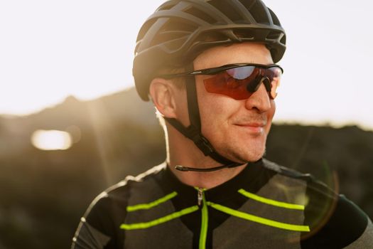 Portrait of male caucasian cyclist with helmet and glasses close up