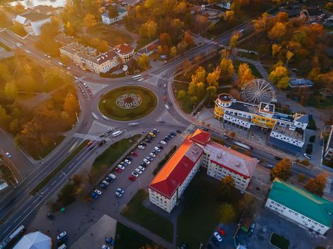 Aerial view of roundabout road with circular cars in small european city at autumn sunset, Kyiv region, Ukraine