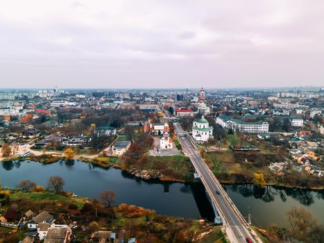 Aerial view of two old churches near river and bridge in small european city at summer day, Kyiv region, Ukraine