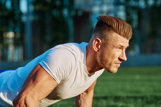 athletic man training with dumbbells in the morning Park. High quality photo