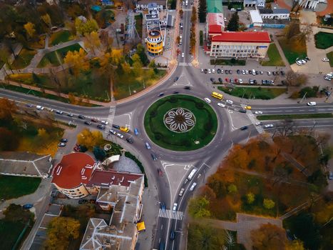 Aerial view of roundabout road with circular cars in small european city at autumn cloudy day, Kyiv region, Ukraine