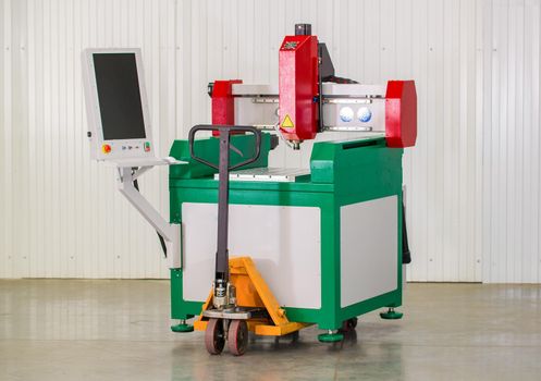 Industrial laser cutter with sparks on hydraulic trolley. The programmed robot head. Modern machine improves quality and productivity.