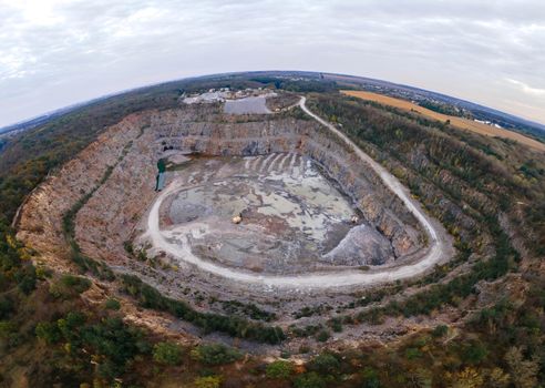 Aerial drone view of career in Europe at summer sunset, crushed stone quarry, beautiful nature round, some excavators, diggers inside