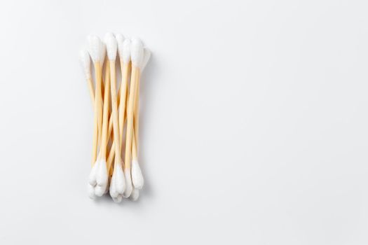 Bamboo cotton ear swabs on white background with copy space. Zero waste hygienic accessory product concept.