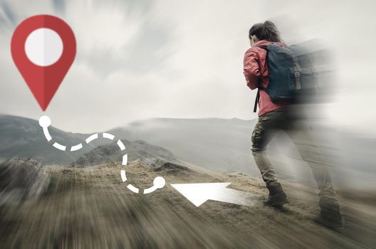 Hiker young woman going up on mountain to route with location GPS pin. Navigation concept. Image with moving fast and motion blur effect.