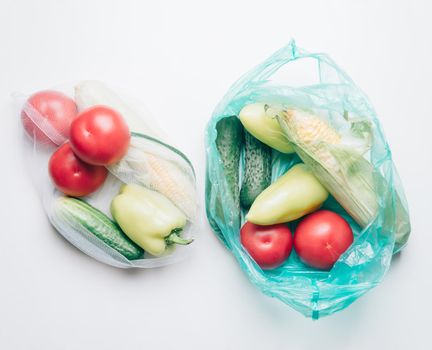 Ecological choice: vegetables in reusable bag or plastic package. Zero waste concept.