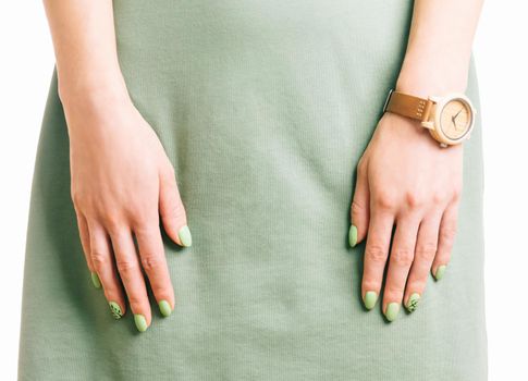 Female hands with green summer style manicure on dress.