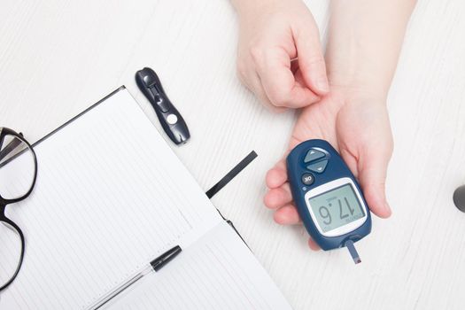 woman measures blood sugar glucose meter, diabetes concept, blood from a finger, glucose test, high blood glucose