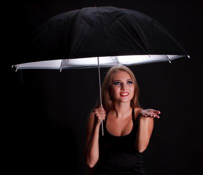 beautiful girl with black umbrella on black background