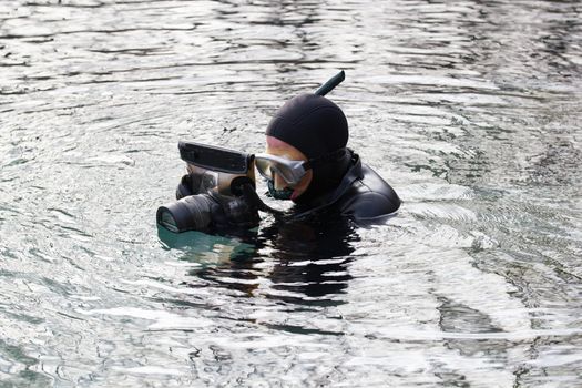 fisherman in wetsuit with photo camera in hands in preparation for a photohunt. Portrait