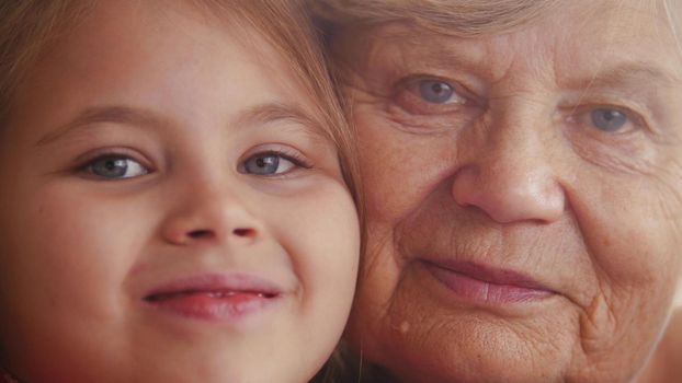 Close up portrait of cute small lovely granddaughter and her charming nice kind granny. Close up photo