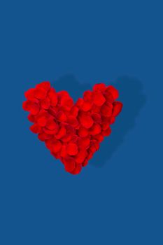 Heart made from red rose petals isolated on blue background . Top view, flat lay. Copy space