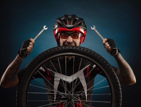 a guy-cyclist in a Bicycle helmet with a Bicycle wheel