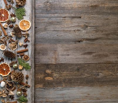 Christmas decorations on an old wooden background with cinnamon and dried orange slices. Space for text