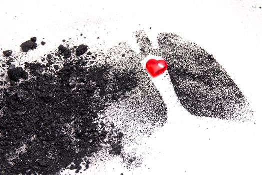 silhouette of human lungs from coal dust on a white background, lungs from pieces of coal and a small red glass heart, health care concept, respiratory diseases, copy space