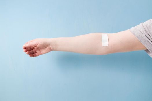 female hand with patch glued with a cross, heart on a patch, blood donor concept