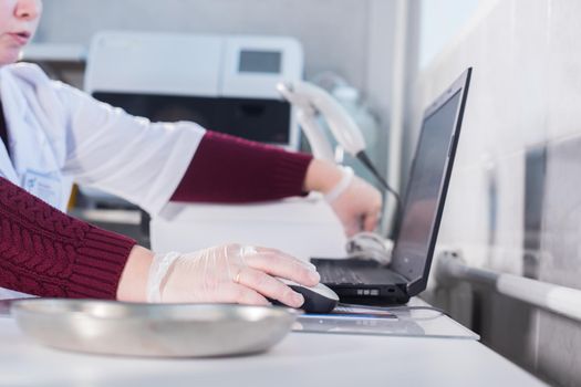 Medical clinic. Nurse works with blood. Working with a laptop. Close up hands
